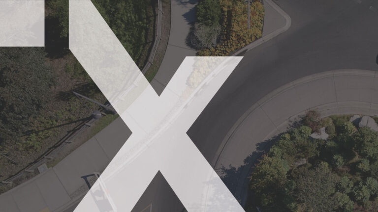 An X icon over an aerial photo of a roundabout.