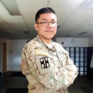 A photo of a man wearing a military uniform with arms crossed.