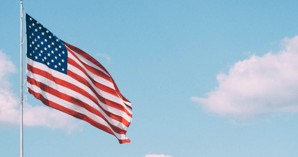 An American flag in front of a blue sky