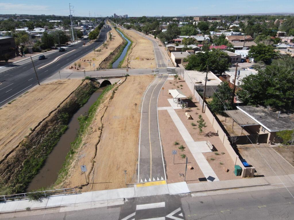 Aerial view of a ditch with water and a paved trail running parallel