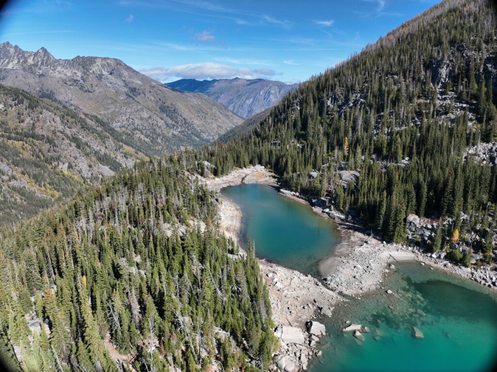 A bird's eye view of two lakes on a mountain separated by a dam