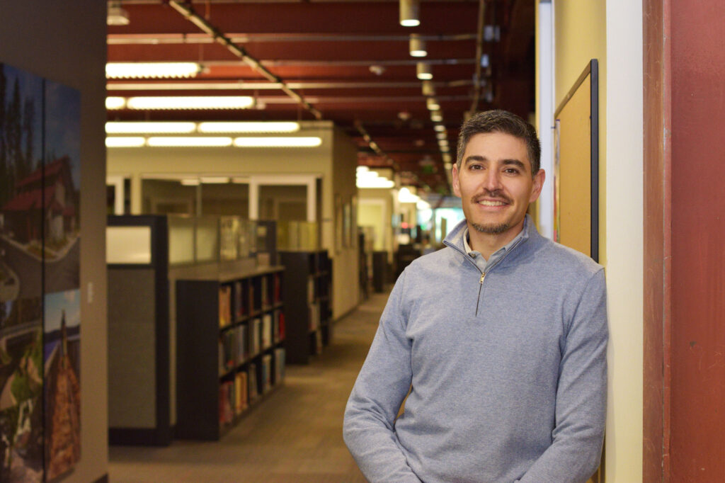 Craig Buitrago stands in an office hallway