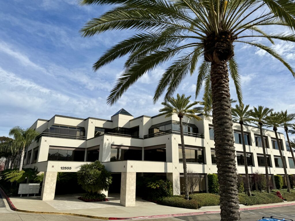 an office building with a palm tree in front