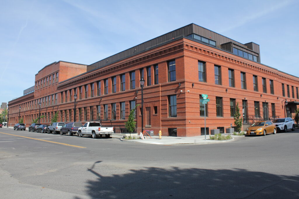 A red brick building with cars parked along the street