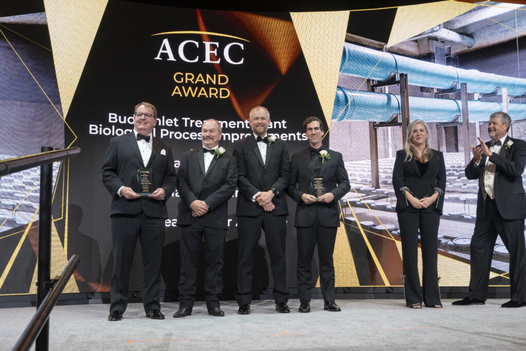 A group of people stand on a stage to accept an award.
