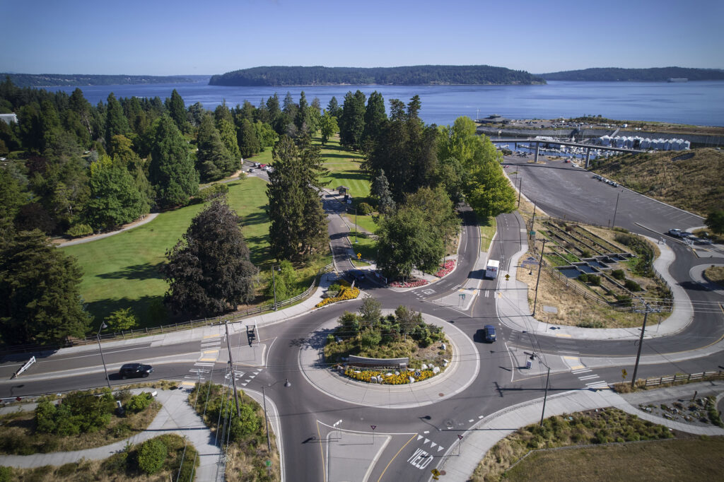 A bird's eye view of a roundabout with water in the background.