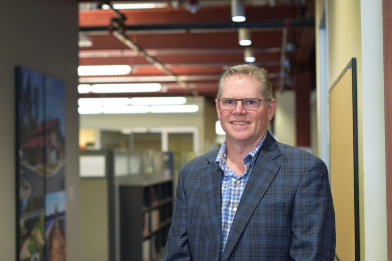 Brian Morkert stands in an office hallway