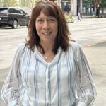 A woman standing in front of a downtown street.