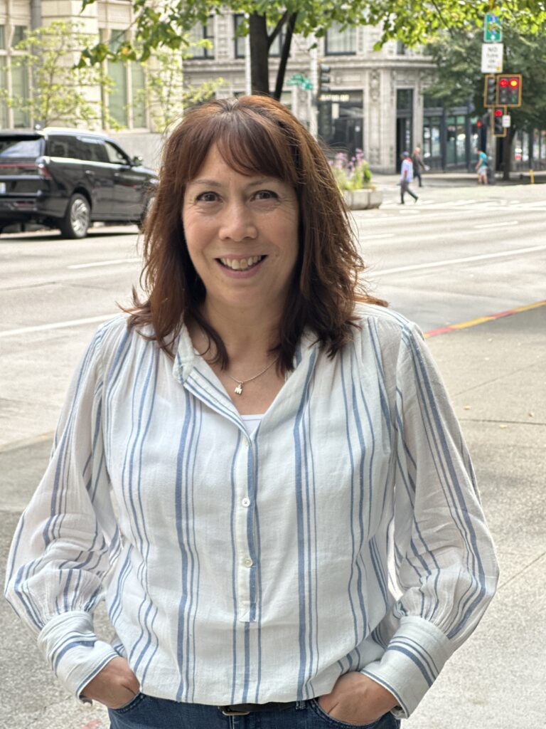 A woman standing in front of a downtown street.