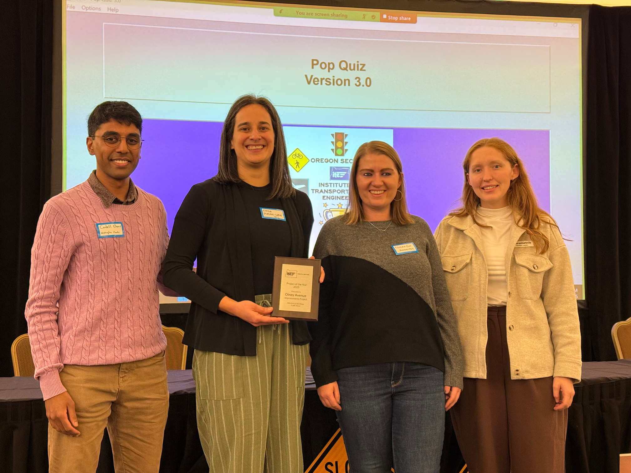 Four people stand on a stage to accept an award.