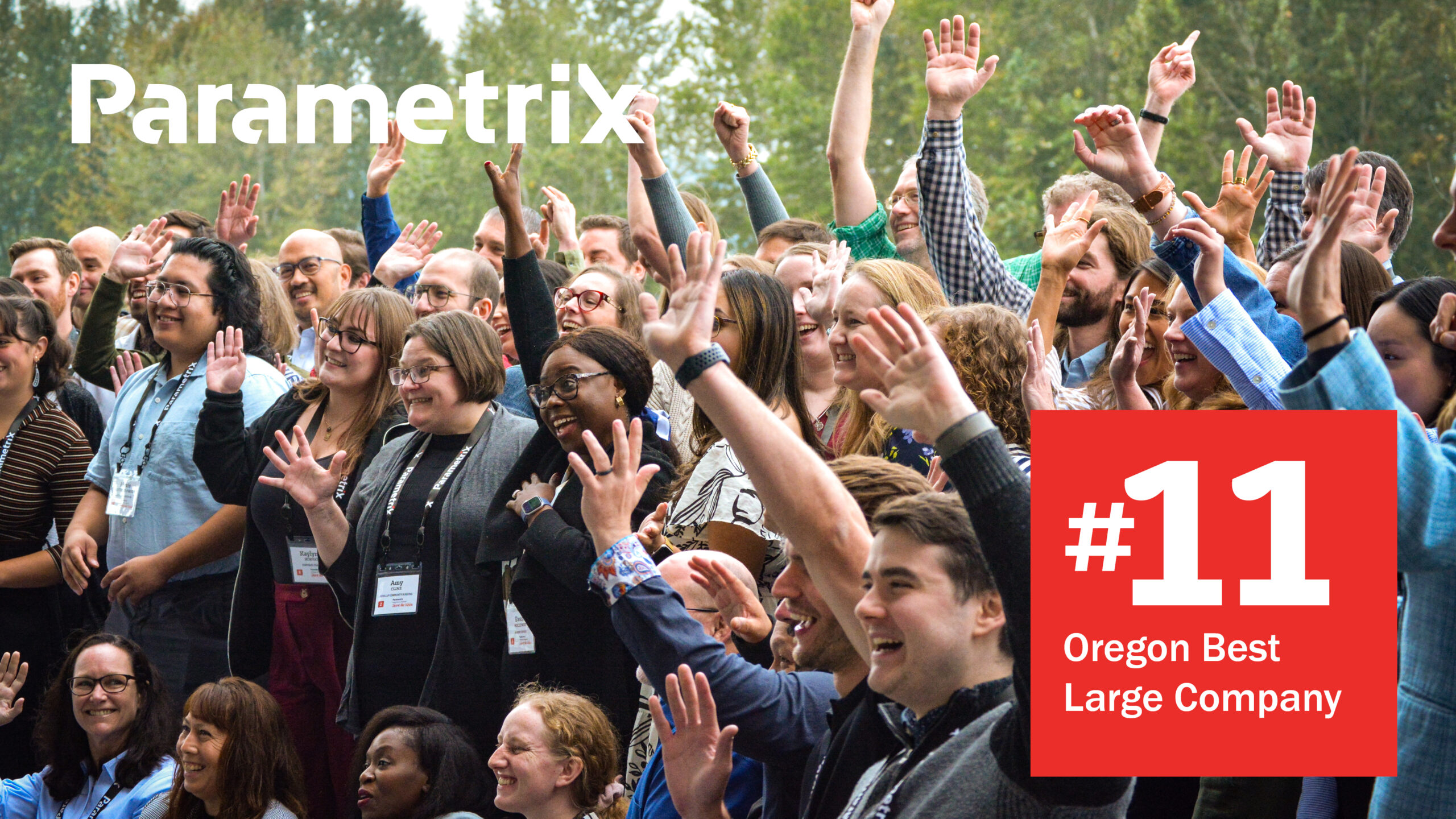 A group of people with their hands in the air and text "#11 Best Large Company in Oregon"