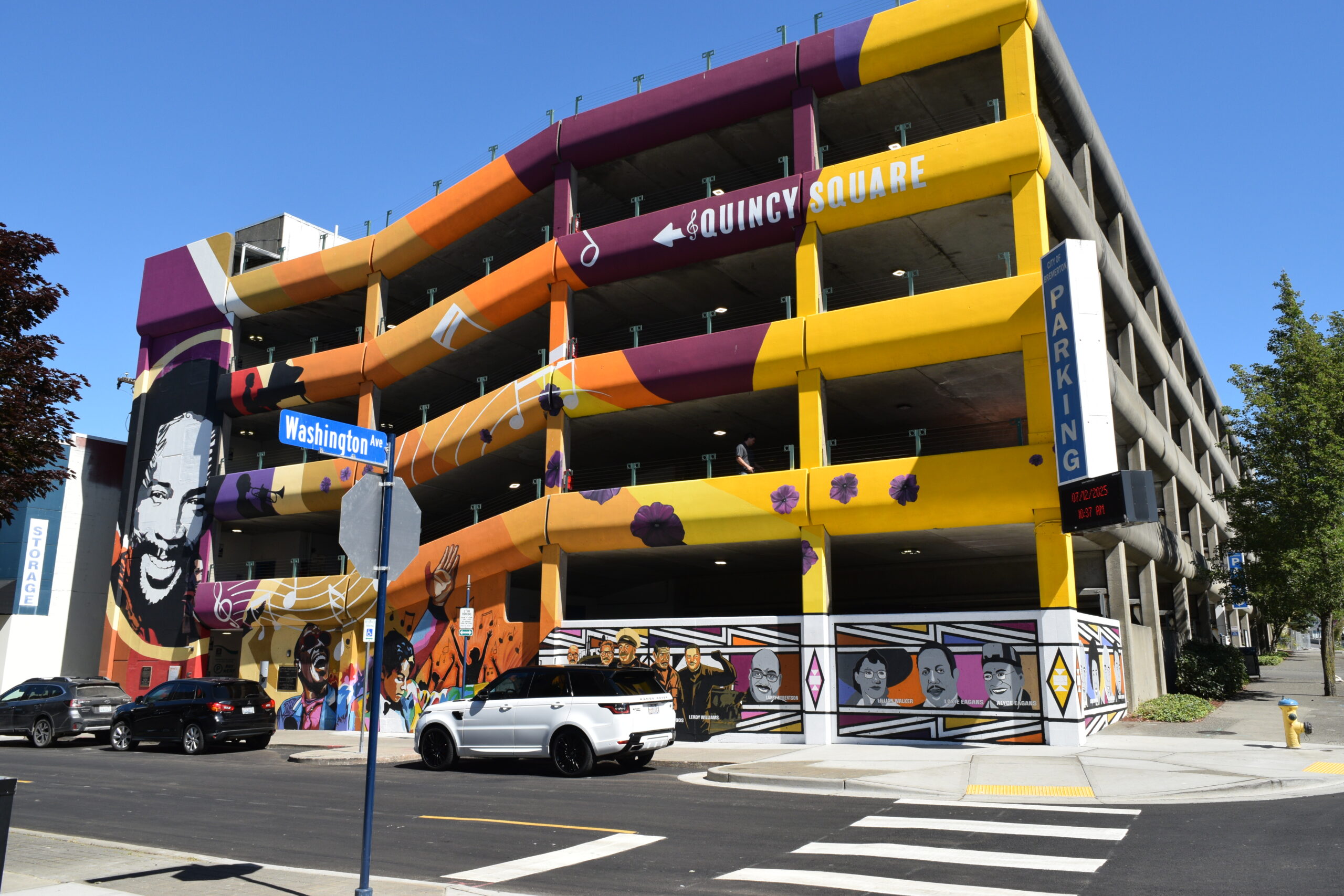 A parking garage with a colorful mural painted on the side.