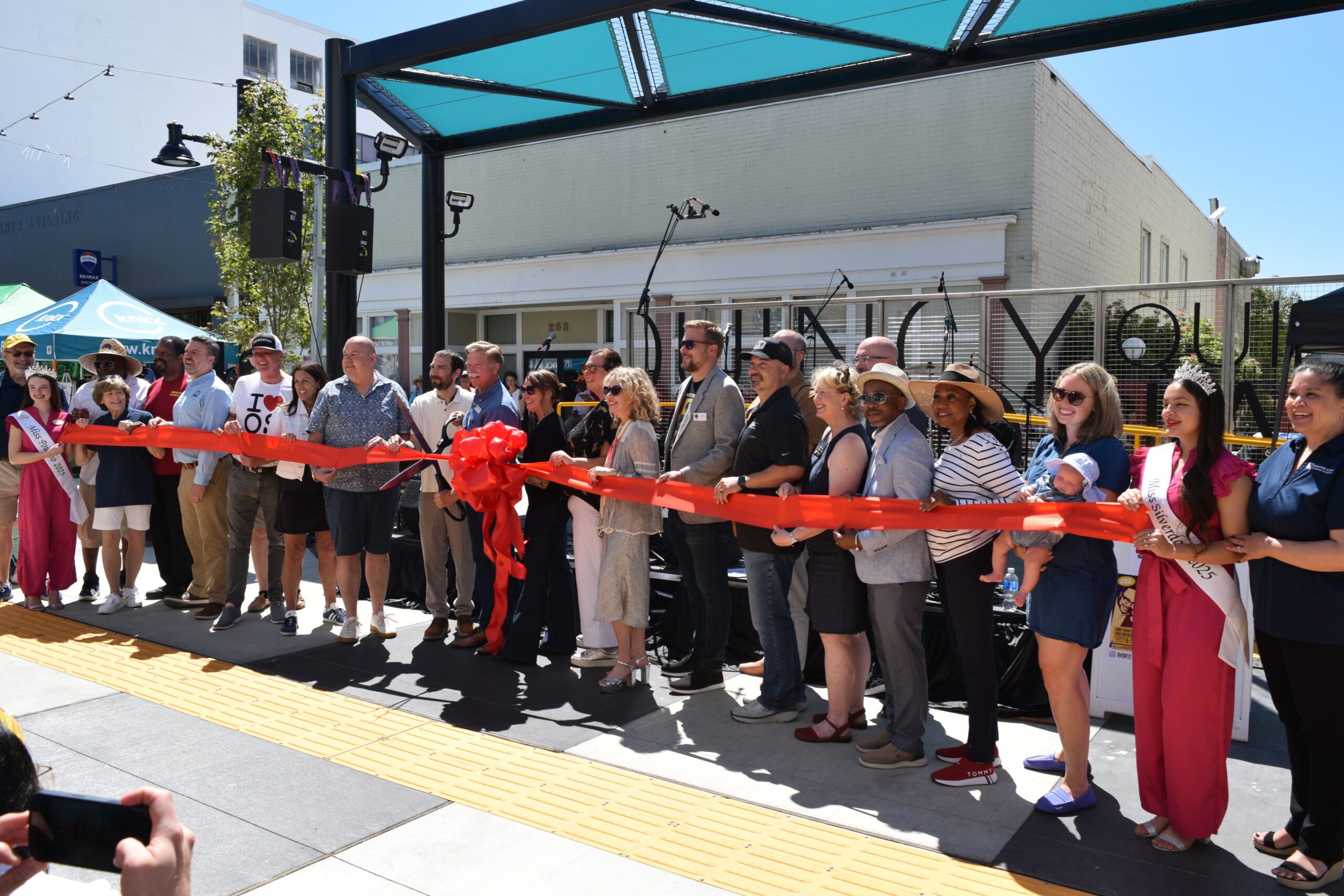 A group of people stand behind a ribbon