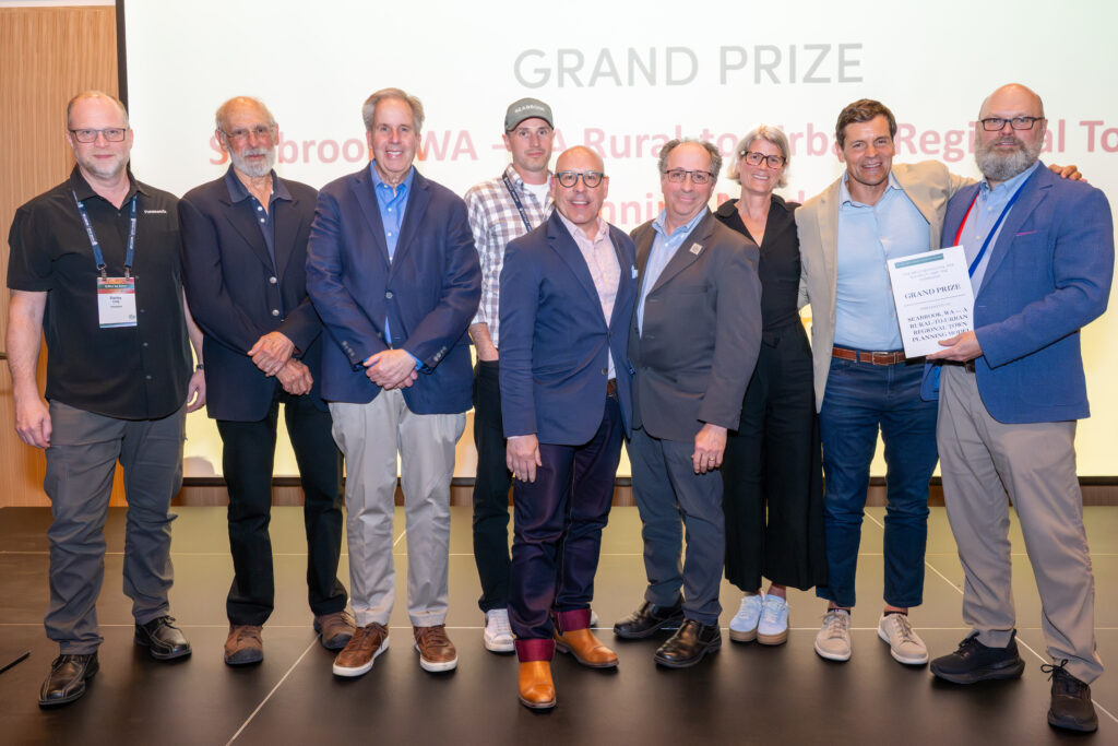A group of people pose for a photo on an awards stage.